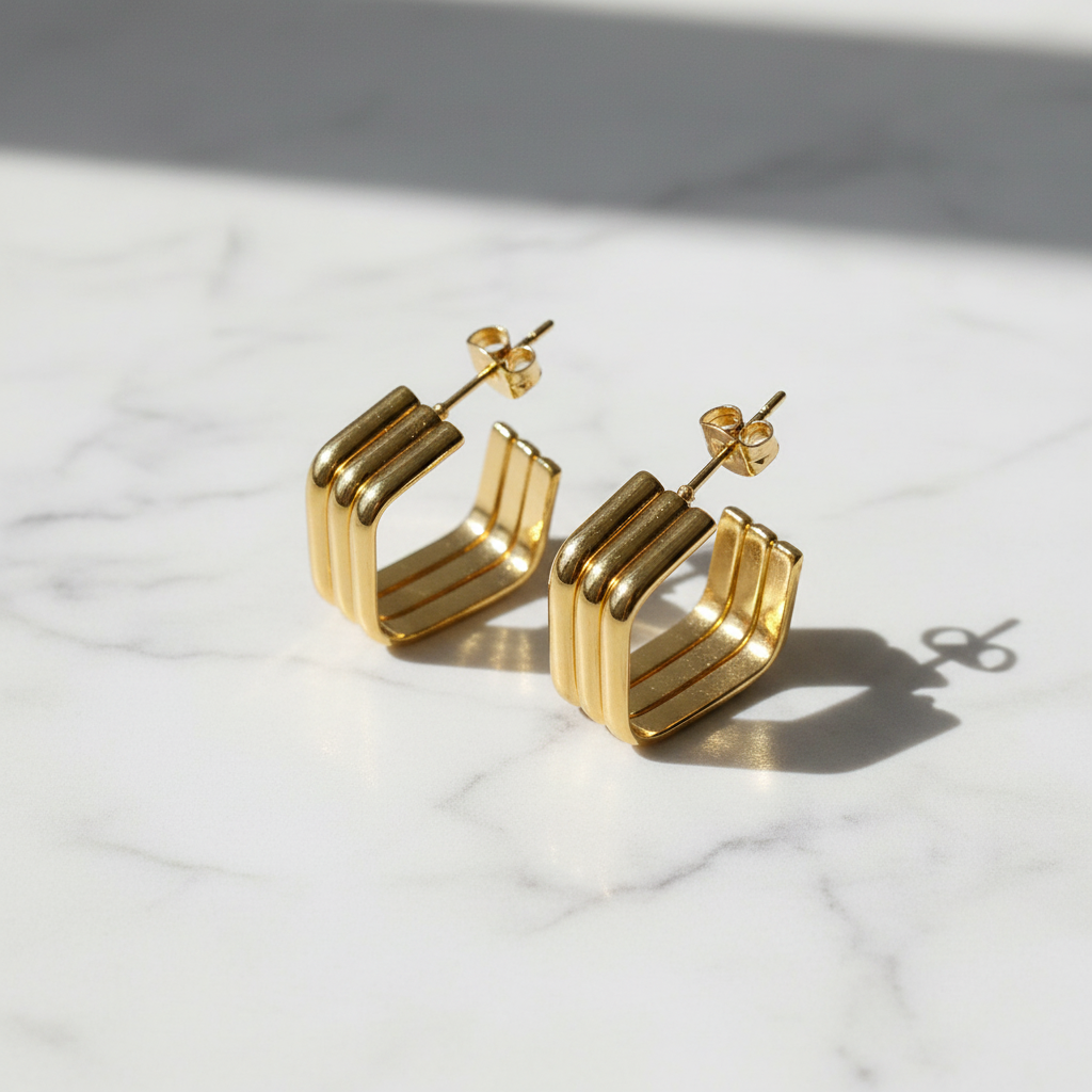 Luxe Ridge Gold Stud Earrings on marble surface