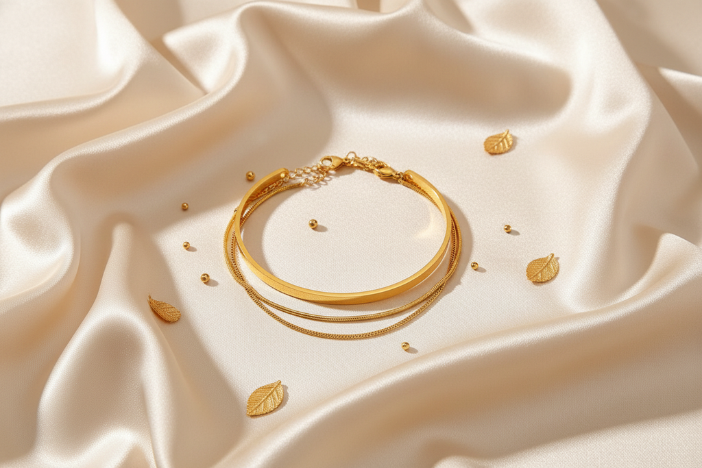 Gold bracelet set on cream silk fabric editorial