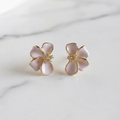 Blush pink flower stud earrings on white marble